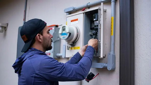 An electrician working on a home's electrical meter