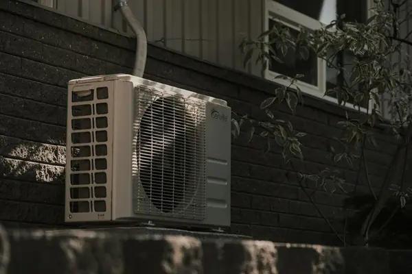 An air conditioning unit mounted on a brick wall